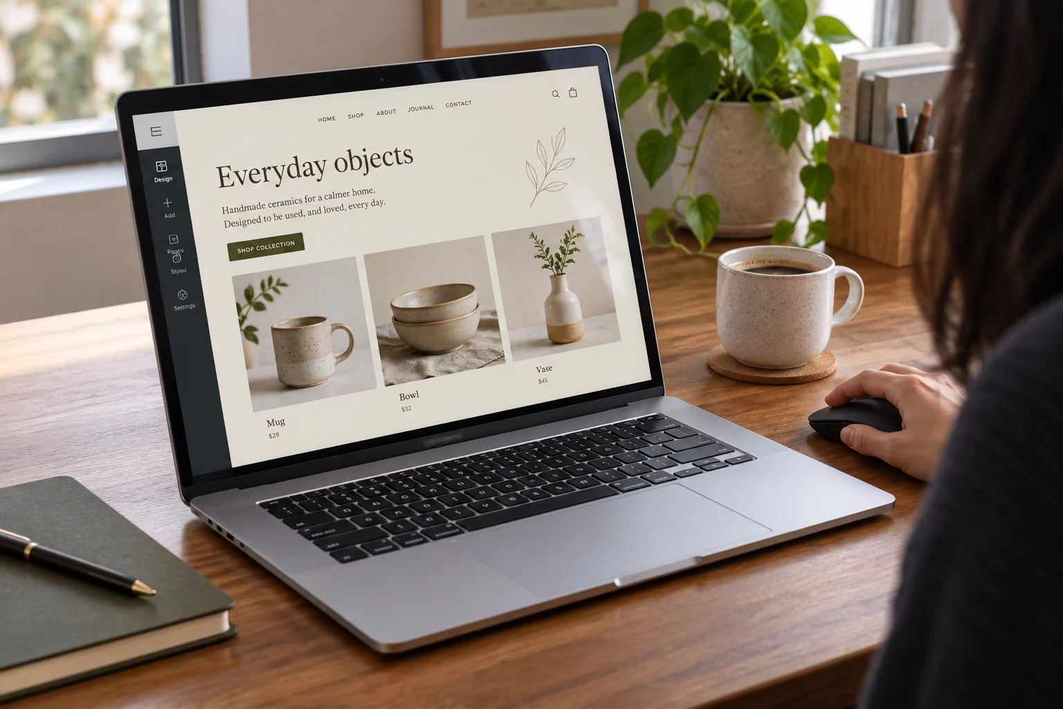 A designer editing a ceramics shop website on a laptop